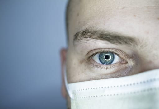 Young doctor with bald head wearing a mask and on a gray background (in studio)