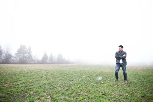 Young adult in a foggy and wet field