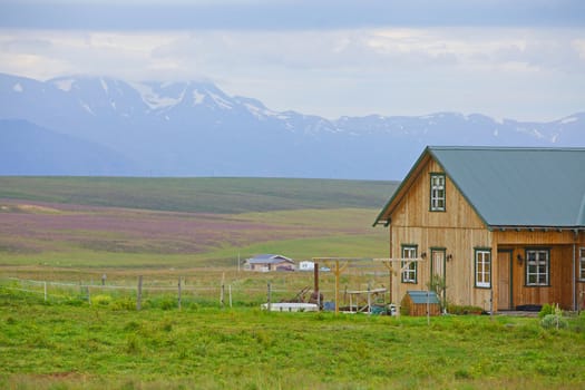 Beautiful house in Iceland. Mountains in background.