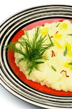 Mashed Potato Garnished with Dill, Spring Onion, Leek and Chili on Red Plate closeup