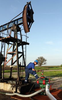 oil worker with pipe wrench and pipeline