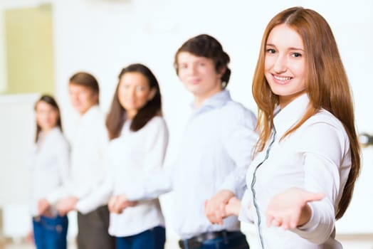 group of people holding hands, woman holds out her hand, the concept of teamwork