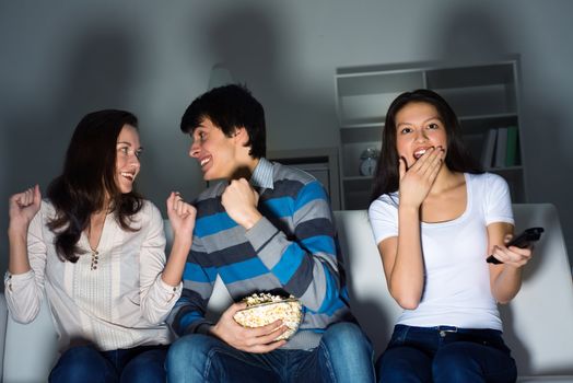 group of young people watching TV on the couch, sports fans