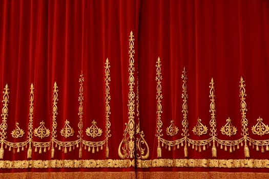 Theatrical red velvet curtain with gold pattern