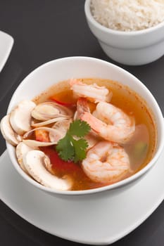 Thai shrimp soup bowl close up with mushrooms and vegetables.