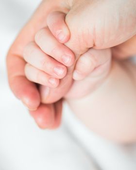 baby's hand holding mother's finger