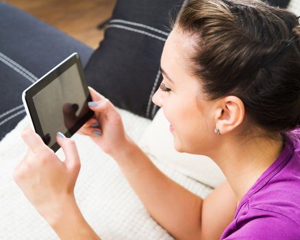 Student girl with tablet pc on the sofa.