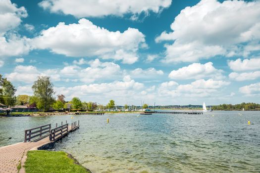 Lake Chiemsee in Germany with sailboat and bright sun.