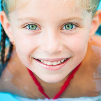 Closeup face of Smiling little girl in swimming pool