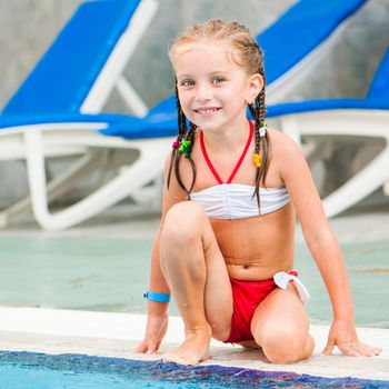 Pretty little girl near swimming pool