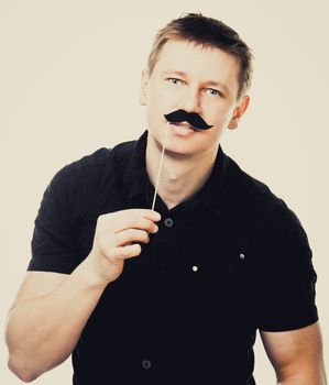 Young man with fake mustache. picture over light background