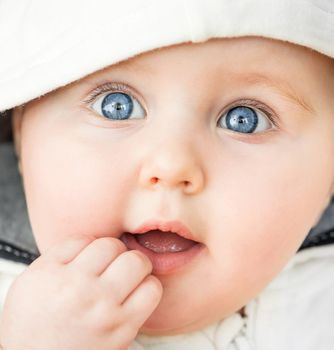 bright closeup portrait of adorable baby in the hood