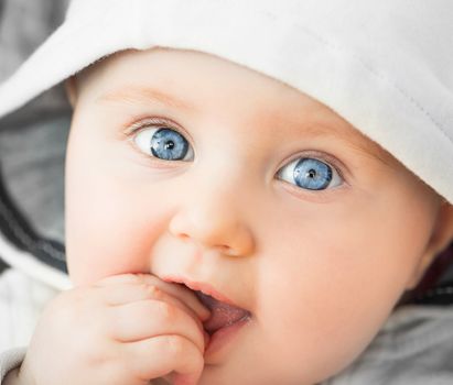 bright closeup portrait of baeutiful baby in the hood