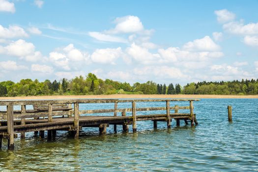 Dilapidated bathing jetty for relaxing in light, green nature at Chiemsee, Germany