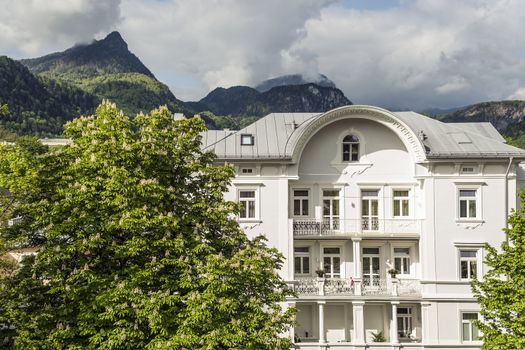 Mansion and chestnutz with panorama of alps with clouds on a sunny day