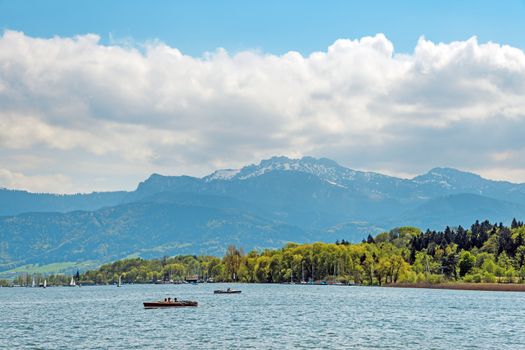 Lake Chiemsee in Germany with paddleboat, sailboats, alps and bright sun.