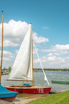 Red sport sailboat in the lake Chiemsee in bright sun