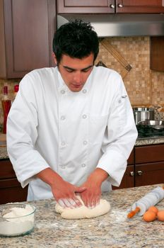 Handsome chef making bread or pasta 