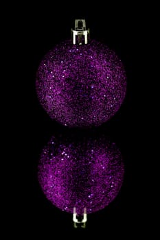 christmas decoration bauble in purple on black background