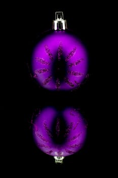 christmas decoration bauble in purple on black background