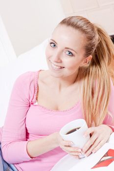 smiling young woman drinking coffee in the morning