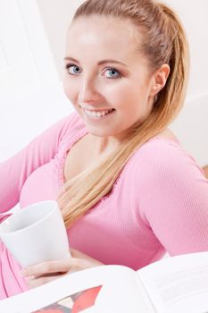 smiling young woman drinking coffee in the morning