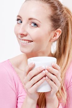 smiling young woman drinking coffee in the morning