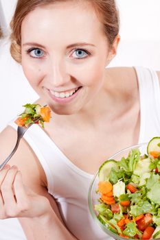 attractive young woman eating fresh healthy salad for lunch