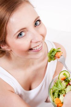 attractive young woman eating fresh healthy salad for lunch