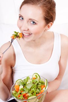 attractive young woman eating fresh healthy salad for lunch
