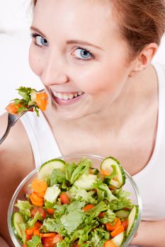 attractive young woman eating fresh healthy salad for lunch