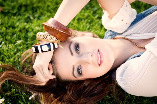 beautiful woman lying in grass with flowers in summer outdoor