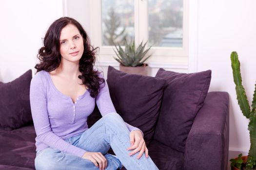 attractive young smiling woman on couch with notebook 