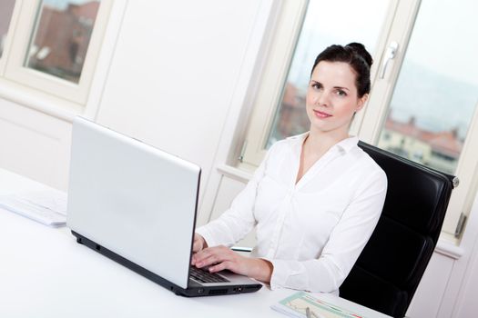 smiling young female callcenter agent with headset in office