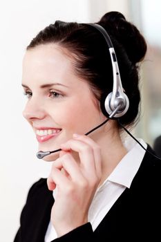 smiling young female callcenter agent with headset in office