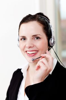 smiling young female callcenter agent with headset in office