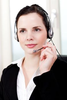 smiling young female callcenter agent with headset in office