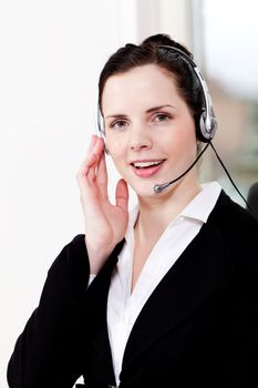 smiling young female callcenter agent with headset in office