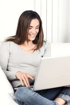 Portrait of woman using laptop on sofa at home