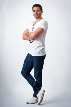 Young brunette Man with Anchor T-shirt standing in front of background