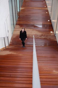 Young Attractive Brunette Woman With Black Clothing Walking Up Stairs