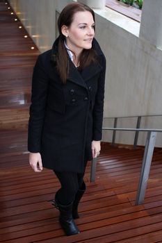 Young Attractive Brunette Woman With Black Clothing Walking Up Stairs