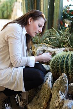 Woman hurt herself on a thorn from a cactus and is holding her hand