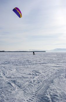 Winter kite skiing on the frozen river
