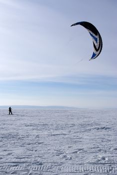 Winter kite skiing on the frozen river