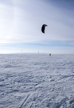 Winter kite skiing on the frozen river