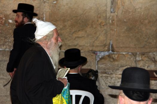 Orthodox Jewish worshipper are praying at the Wailing Wall. Western Wall is located in Old City in Jerusalem. It is site for Jewish prayers for centuries.
