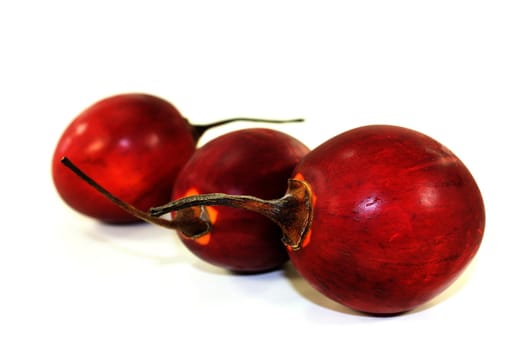 three red tamarillo in front of white background