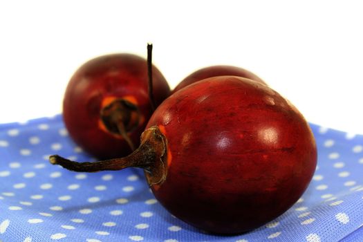 three red tamarillo in front of white background