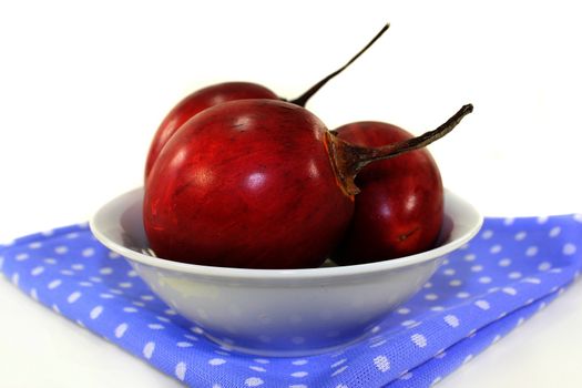 three red tamarillo in front of white background